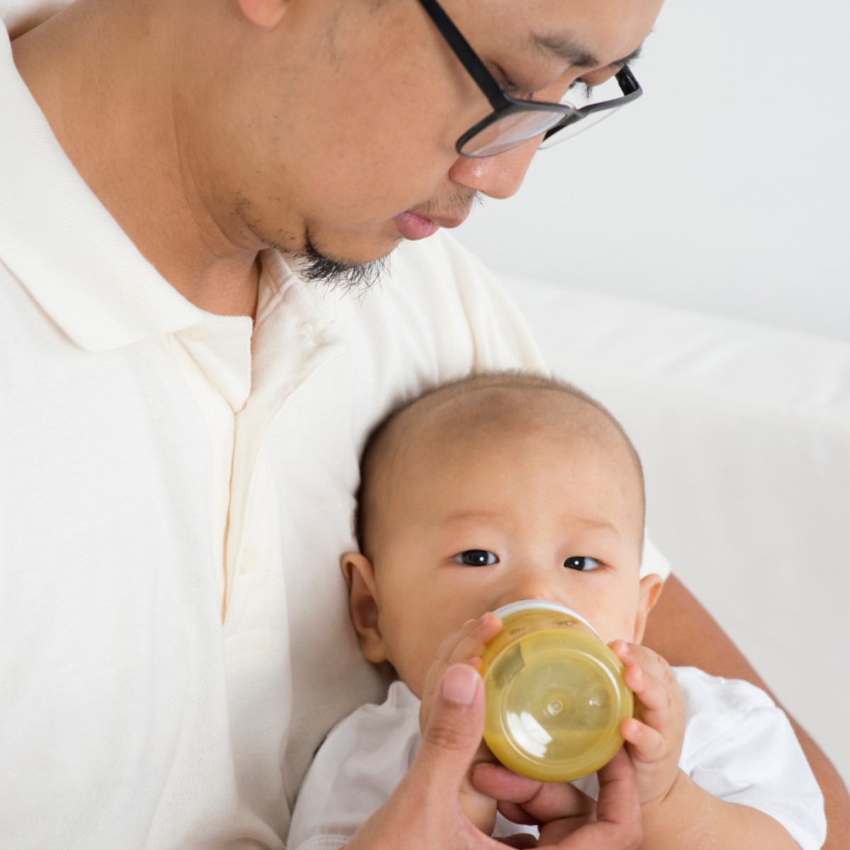A person feeding a baby with a bottle